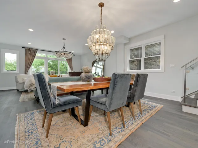 a dining room with furniture a chandelier and wooden floor