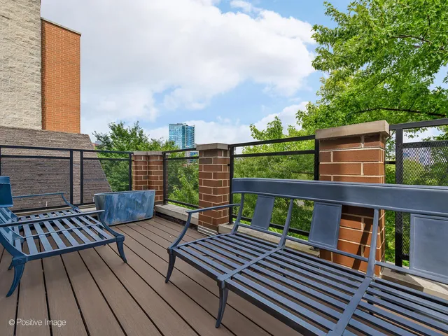 a view of a roof deck with wooden floor and outdoor seating