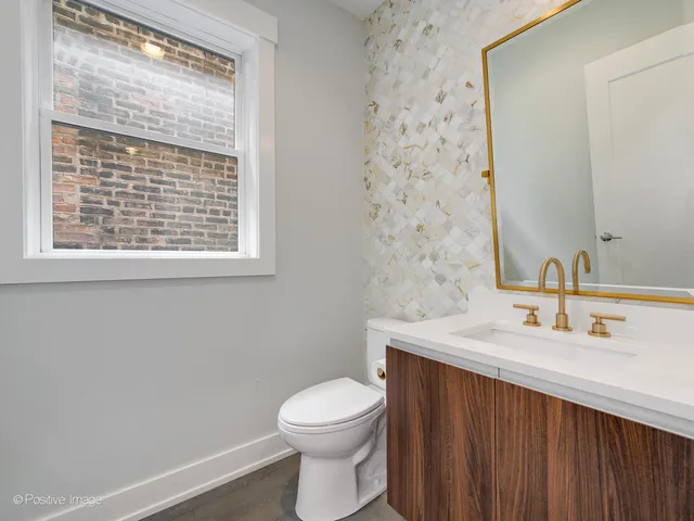 a bathroom with a sink a toilet and a window