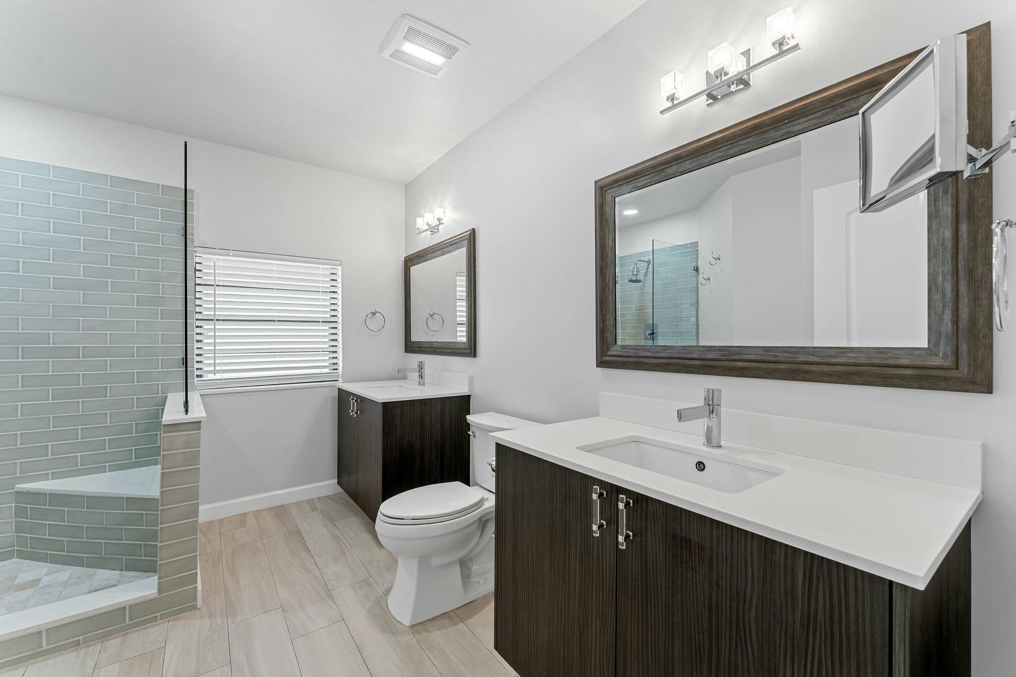 23032 Island View, Unit H Boca Raton, FL 33433 - Photo 14 of 30 a bathroom with a toilet sink double vanity and mirror