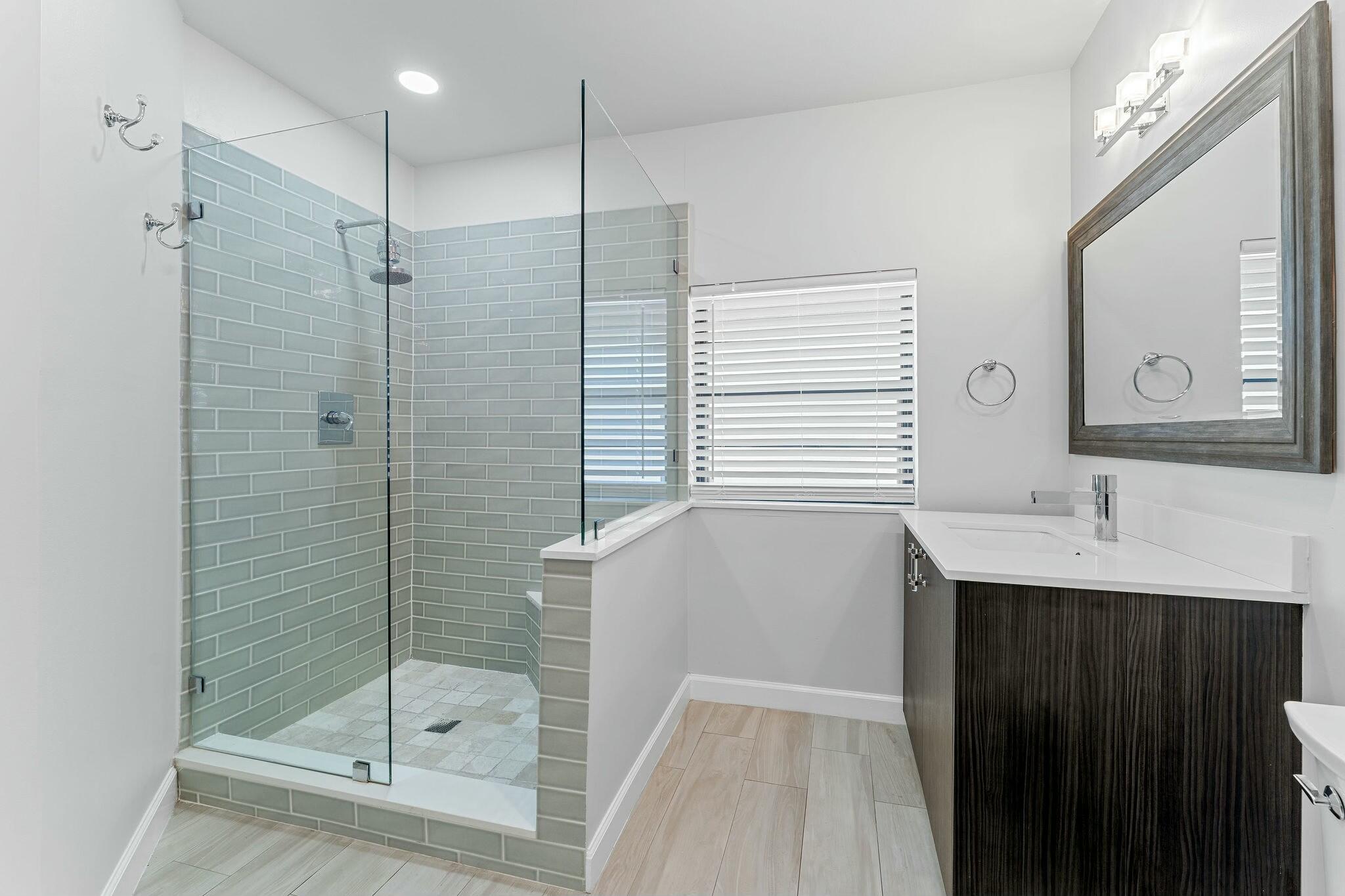 23032 Island View, Unit H Boca Raton, FL 33433 - Photo 15 of 30 a bathroom with a shower sink and mirror