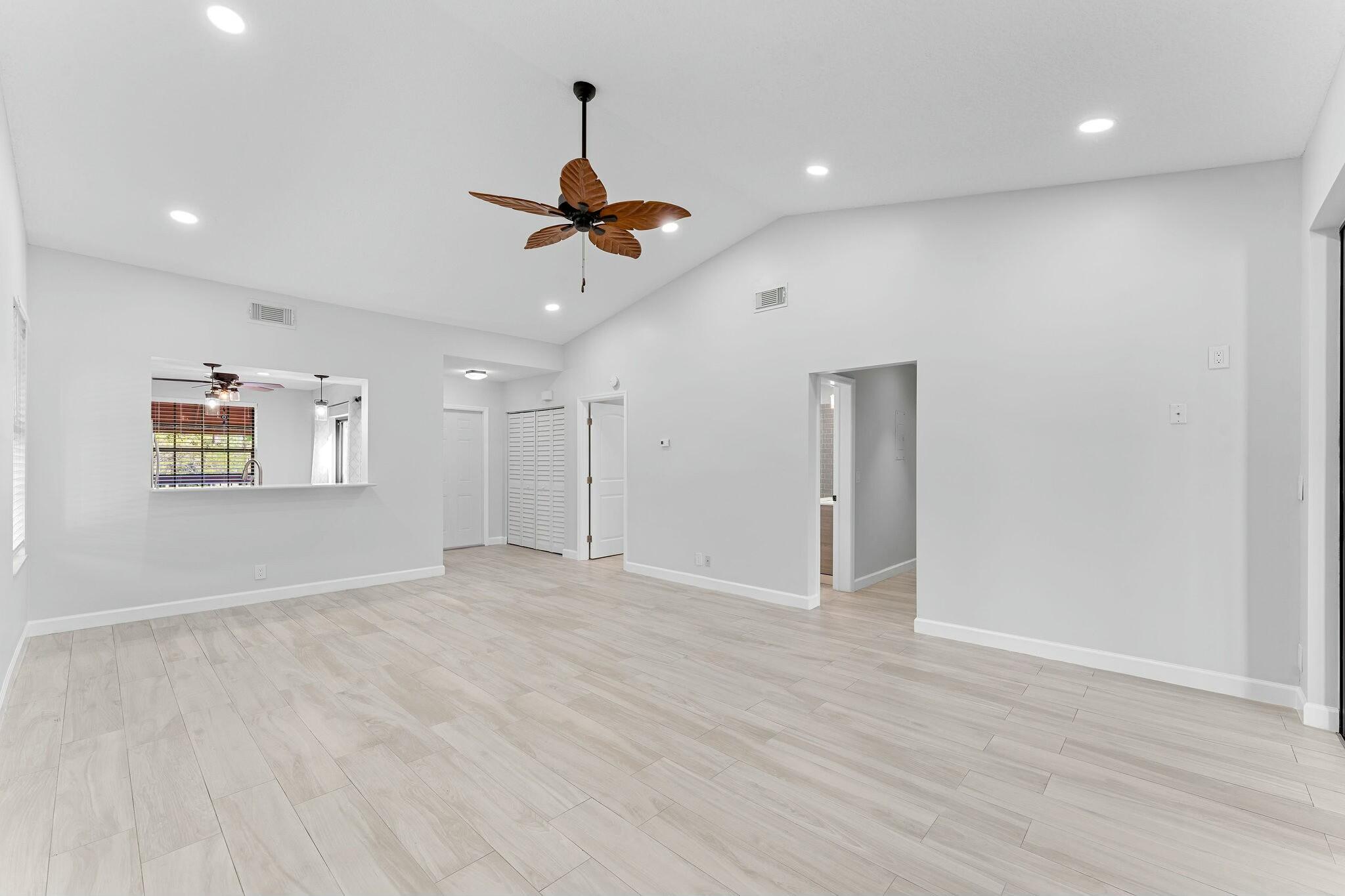 23032 Island View, Unit H Boca Raton, FL 33433 - Photo 5 of 30 an empty room with windows and ceiling fan