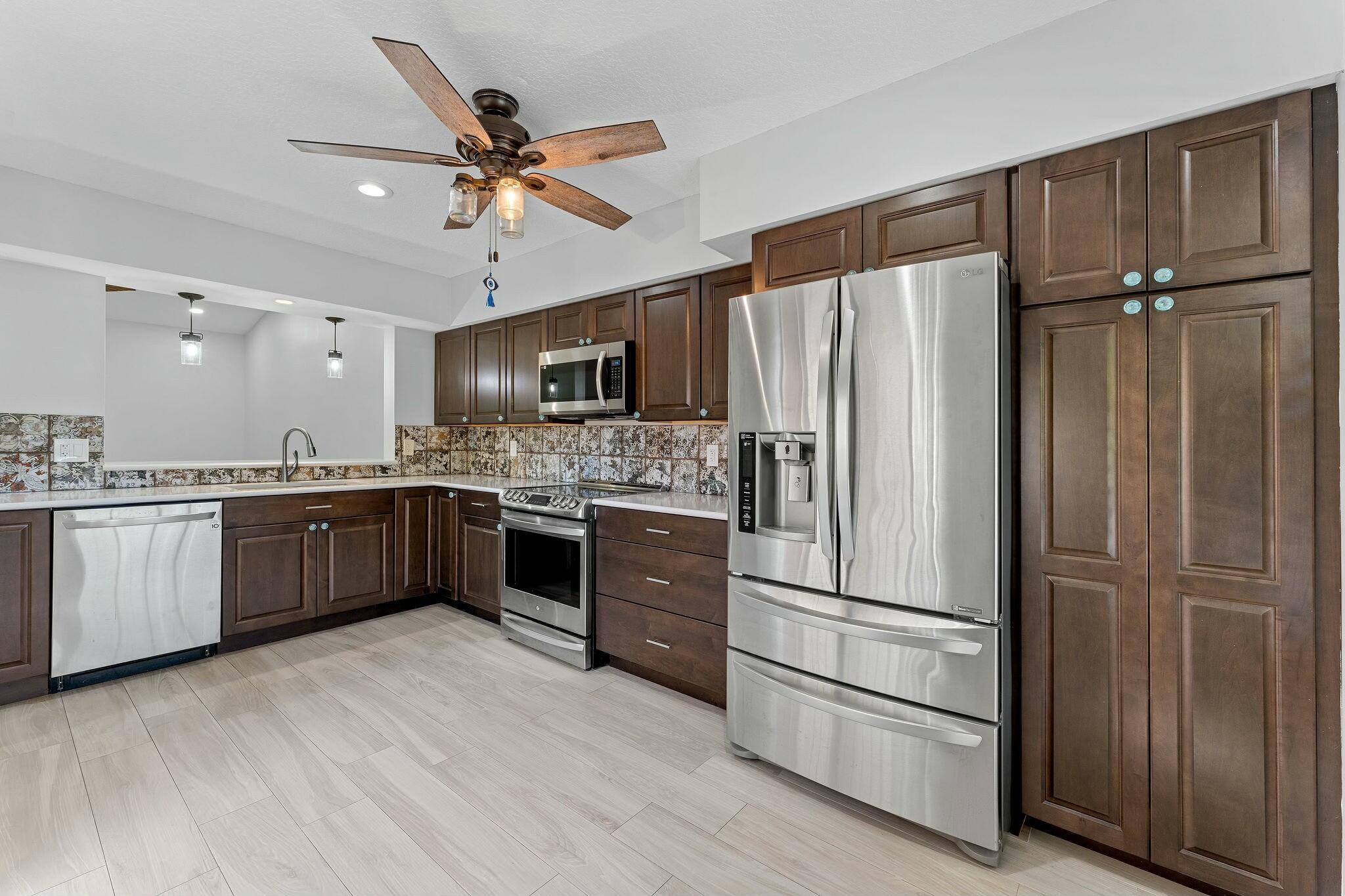23032 Island View, Unit H Boca Raton, FL 33433 - Photo 6 of 30 a kitchen with granite countertop stainless steel appliances and refrigerator