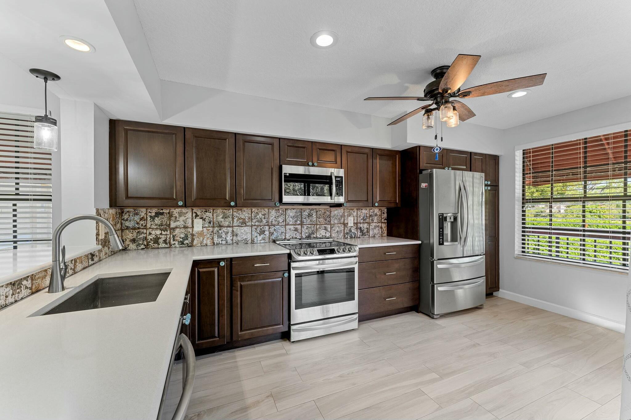 23032 Island View, Unit H Boca Raton, FL 33433 - Photo 7 of 30 a kitchen with a sink stainless steel appliances and cabinets