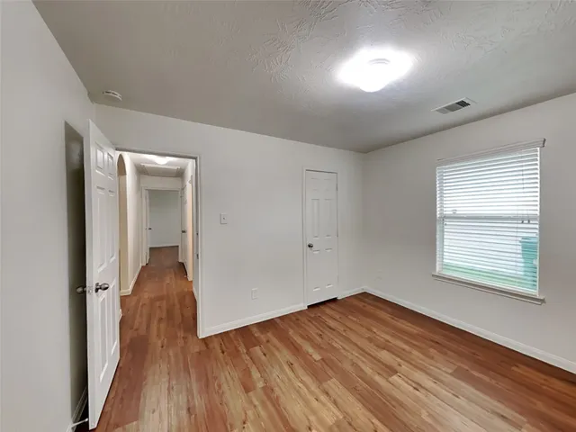 a view of a room with wooden floor and a window
