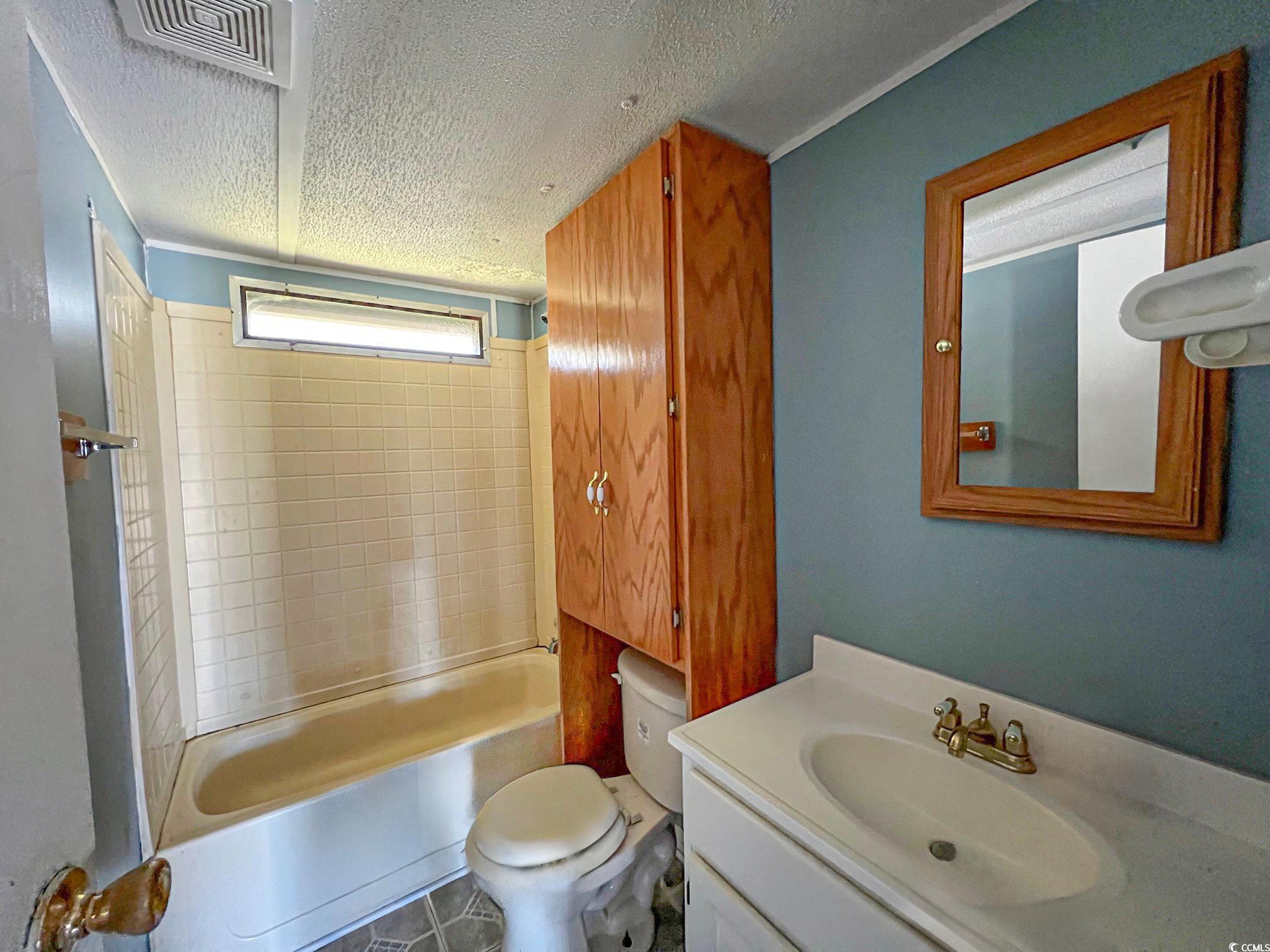 2911 Mt Olive Road Loris, SC 29569 - Photo 11 of 16 Full bathroom featuring toilet, tiled shower / bath combo, vanity, and a textured ceiling