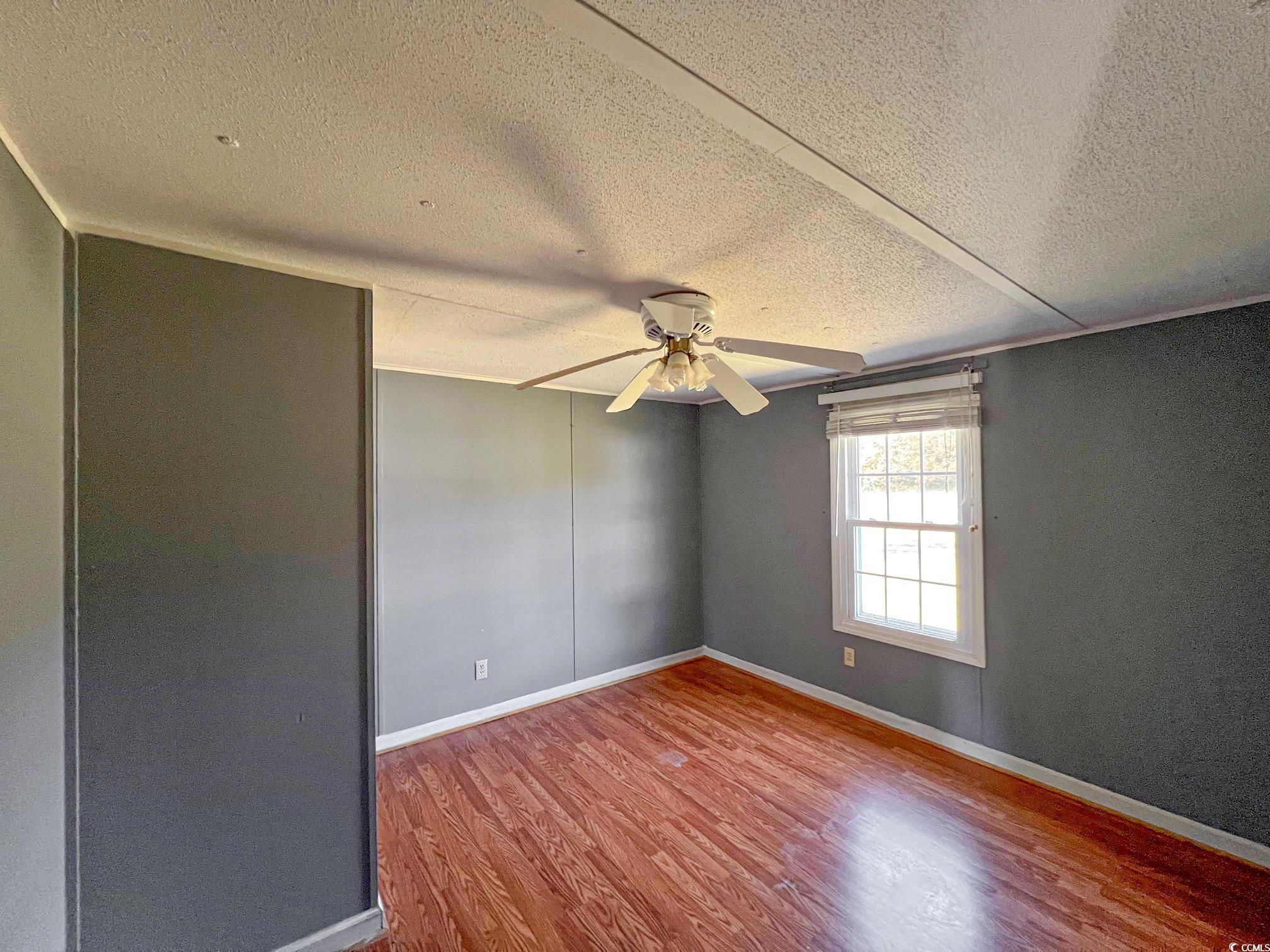 2911 Mt Olive Road Loris, SC 29569 - Photo 9 of 16 Unfurnished room featuring hardwood / wood-style floors, ceiling fan, and a textured ceiling