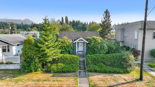 a view of a house with a yard and potted plants