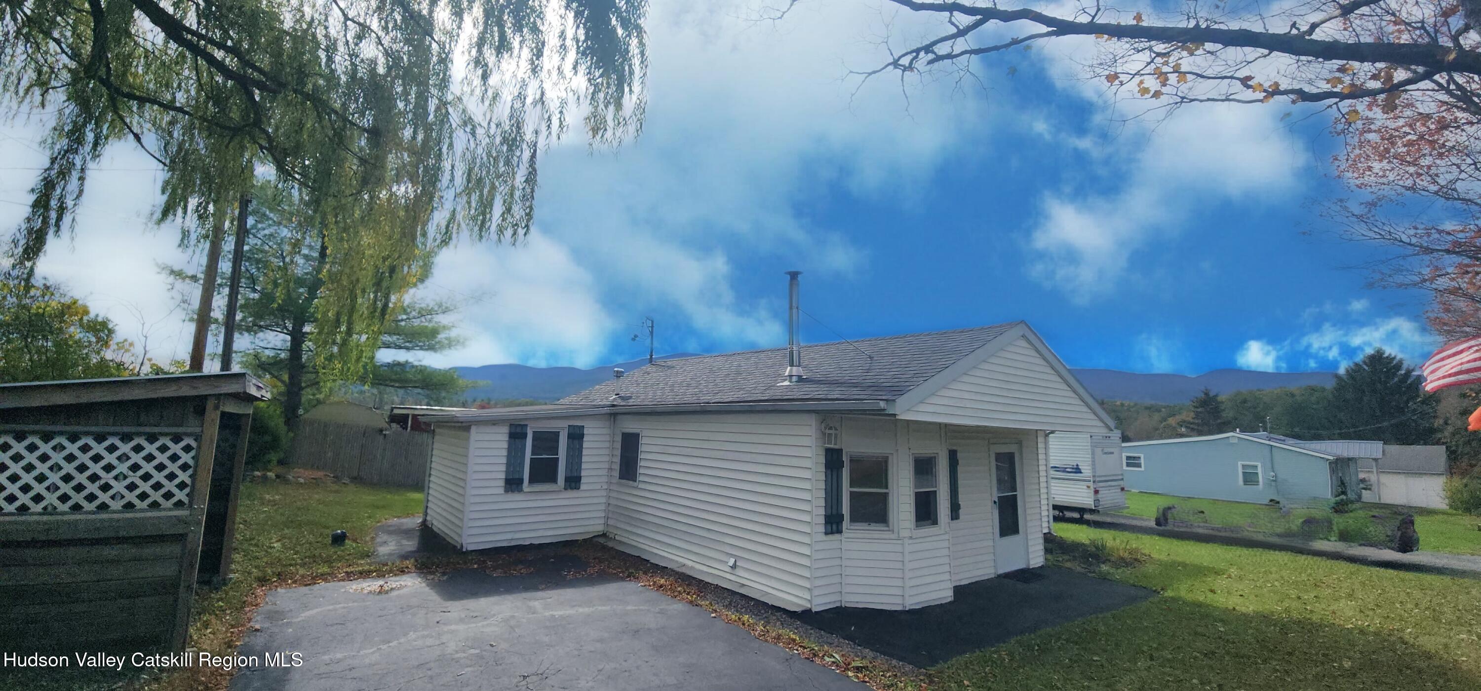 a view of a small house with a yard