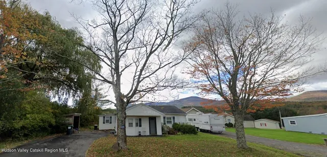 a view of house with a yard