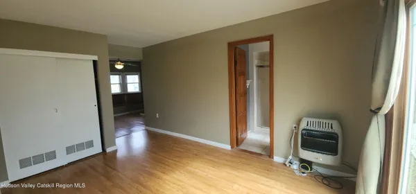 a view of a hallway with bathroom and wooden floor