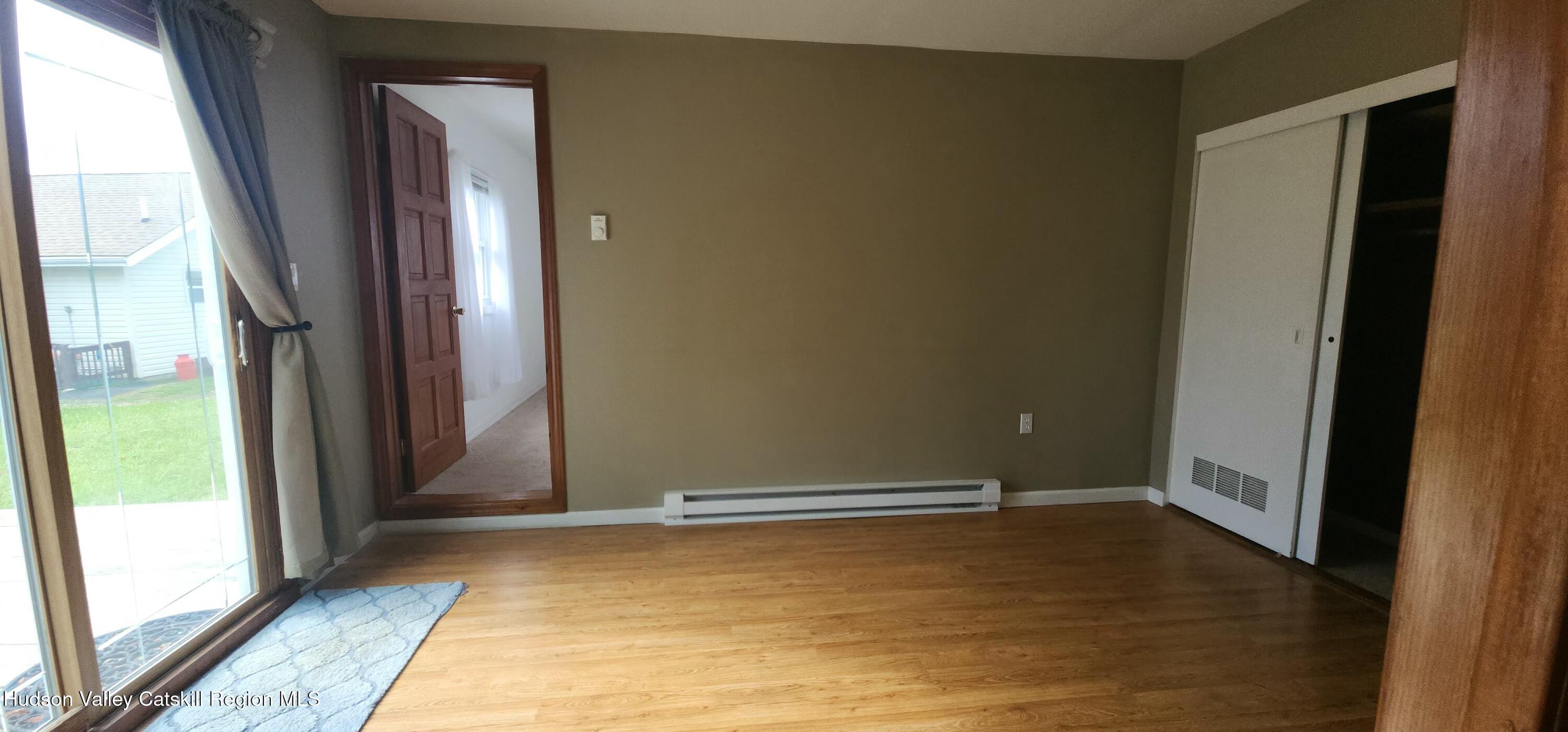 231 Stone Bridge Road Cornwallville, NY 12418 - Photo 9 of 18 an empty room with wooden floor and a window