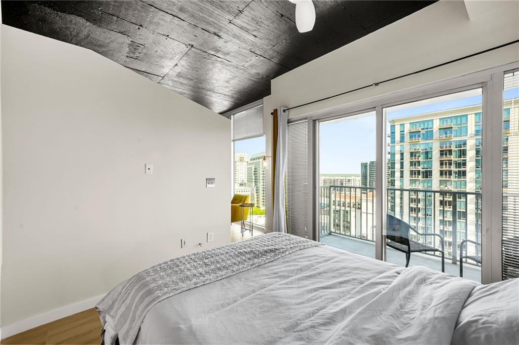 250 Pharr Road Northeast, Unit 1702 Atlanta, GA 30305 - Photo 11 of 23 a bedroom with a large bed and a large window