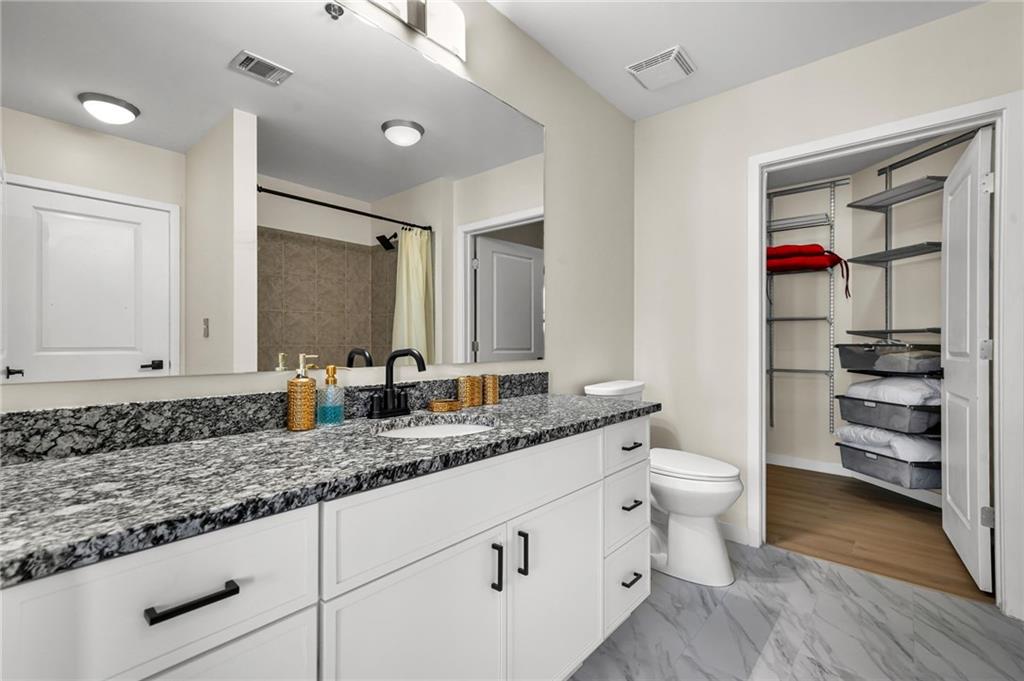 250 Pharr Road Northeast, Unit 1702 Atlanta, GA 30305 - Photo 13 of 23 a bathroom with a granite countertop sink and a mirror
