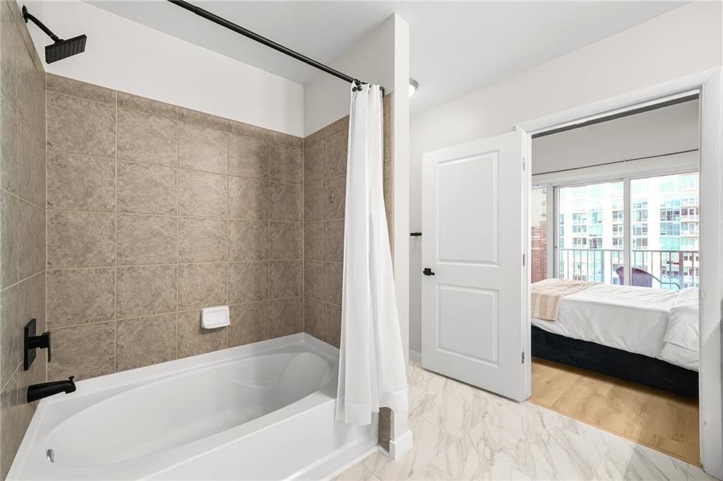 250 Pharr Road Northeast, Unit 1702 Atlanta, GA 30305 - Photo 15 of 23 a bathroom with a bathtub and a shower