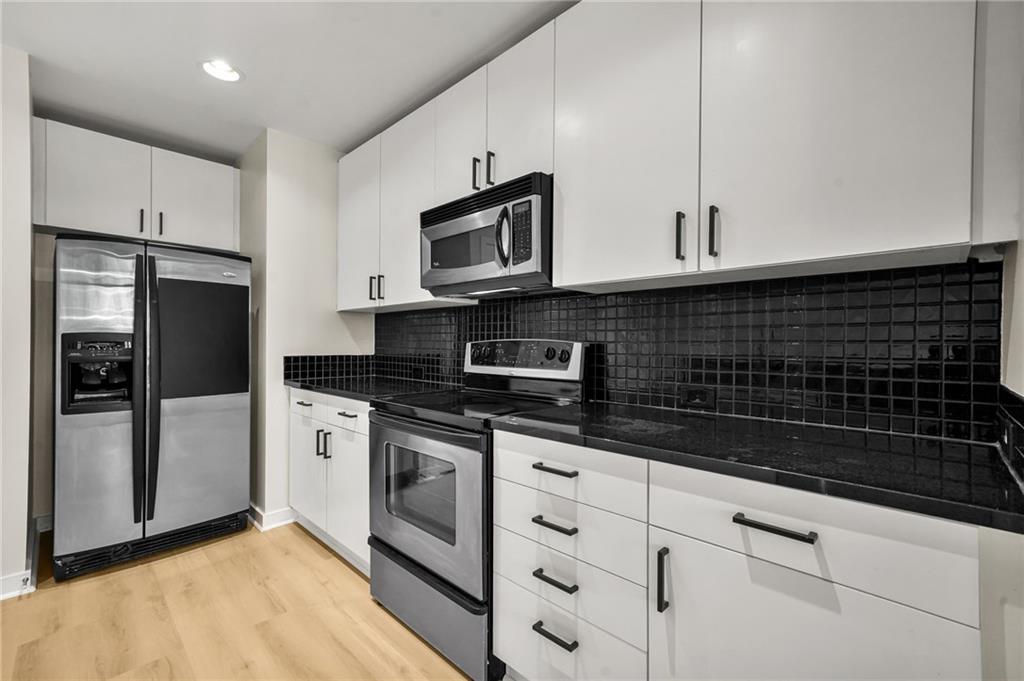 250 Pharr Road Northeast, Unit 1702 Atlanta, GA 30305 - Photo 18 of 23 a kitchen with stainless steel appliances granite countertop a sink a stove a refrigerator and cabinets