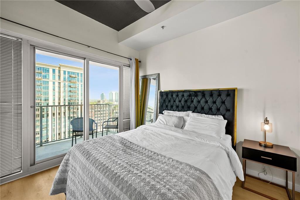 250 Pharr Road Northeast, Unit 1702 Atlanta, GA 30305 - Photo 20 of 23 a bedroom with a large bed and a lamp next to a window