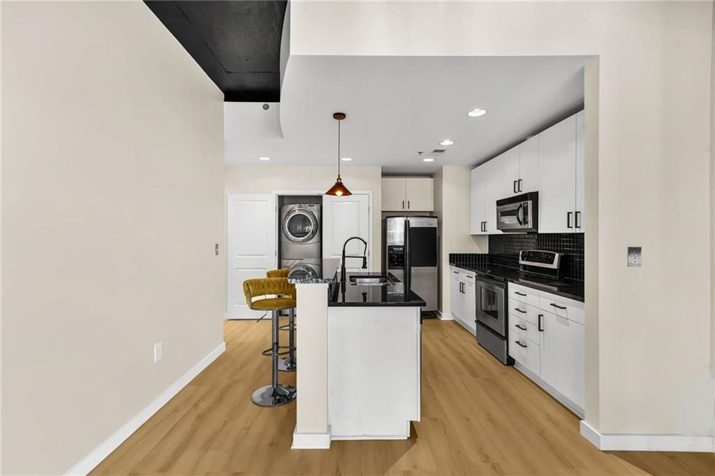 250 Pharr Road Northeast, Unit 1702 Atlanta, GA 30305 - Photo 3 of 23 a kitchen with stainless steel appliances granite countertop a refrigerator and a stove top oven