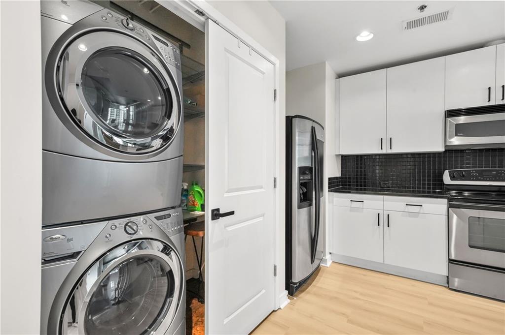 250 Pharr Road Northeast, Unit 1702 Atlanta, GA 30305 - Photo 4 of 23 a kitchen with a washer and dryer