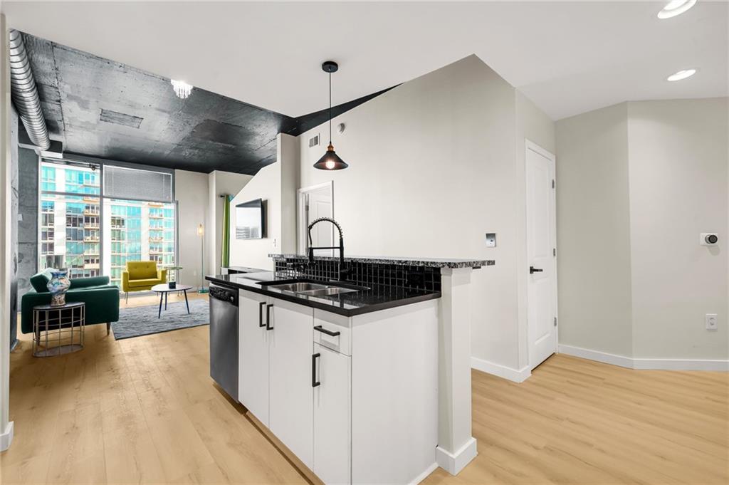 250 Pharr Road Northeast, Unit 1702 Atlanta, GA 30305 - Photo 5 of 23 a kitchen with stainless steel appliances granite countertop a stove and a wooden floors