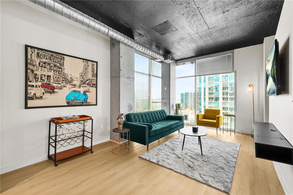 250 Pharr Road Northeast, Unit 1702 Atlanta, GA 30305 - Photo 7 of 23 a living room with furniture and a flat screen tv