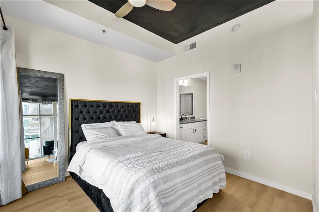 250 Pharr Road Northeast, Unit 1702 Atlanta, GA 30305 - Photo 10 of 23 a bedroom with a large bed and wooden floor