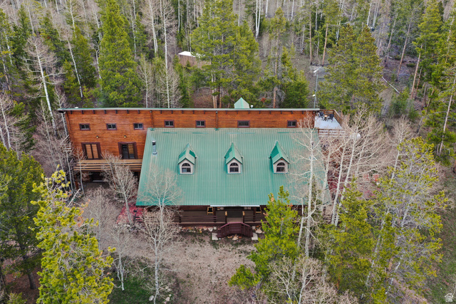 4725 Pine Ridge Road Evanston, UT 82930 - Photo 66 of 82 Wood-sided residence featuring a green metal roof with dormer windows, multiple balconies, and an elevated deck