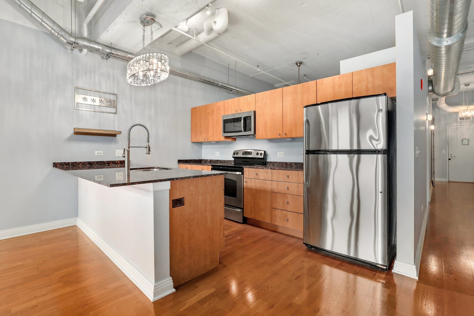 565 West Quincy Street, Unit 717 Chicago, IL 60661 - Photo 11 of 37 a kitchen with stainless steel appliances granite countertop a refrigerator a stove a sink dishwasher and a dining table with wooden floor