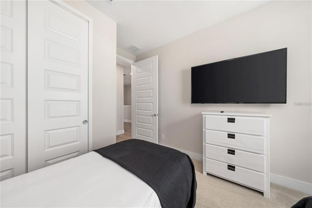 7834 Spectrum Drive Reunion, FL 34747 - Photo 12 of 16 a bedroom with a bed and a flat screen tv