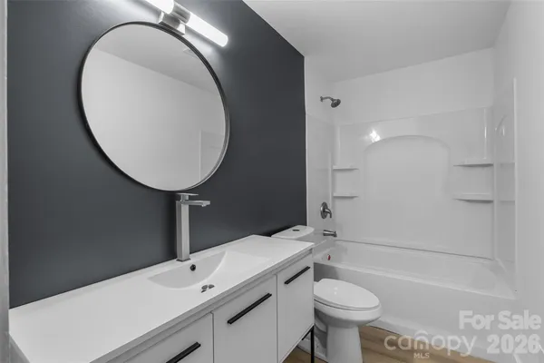 a bathroom with a granite countertop sink toilet a large mirror and shower