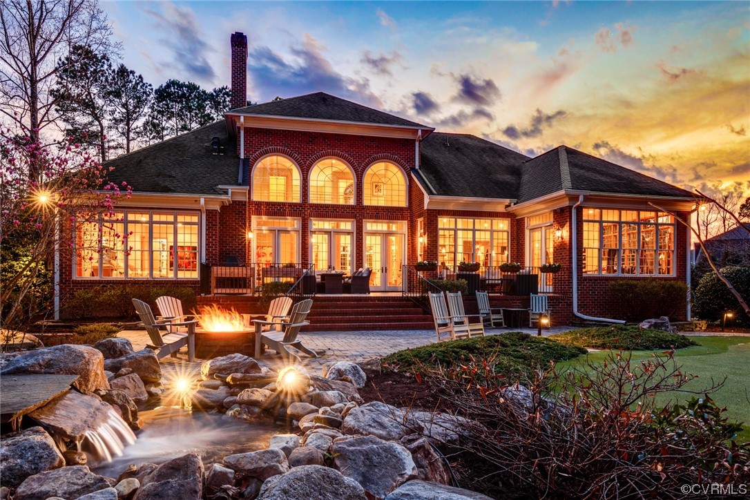 a view of swimming pool with lawn chairs and a fire pit