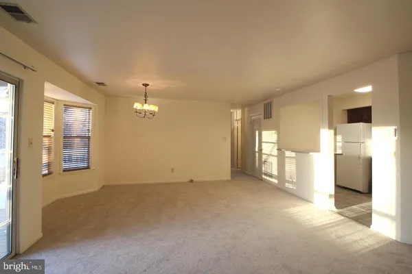 a view of empty room with a kitchen