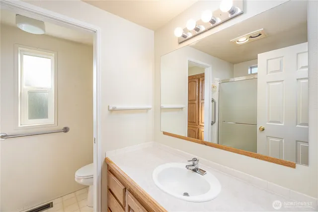 a bathroom with a sink a toilet and a mirror