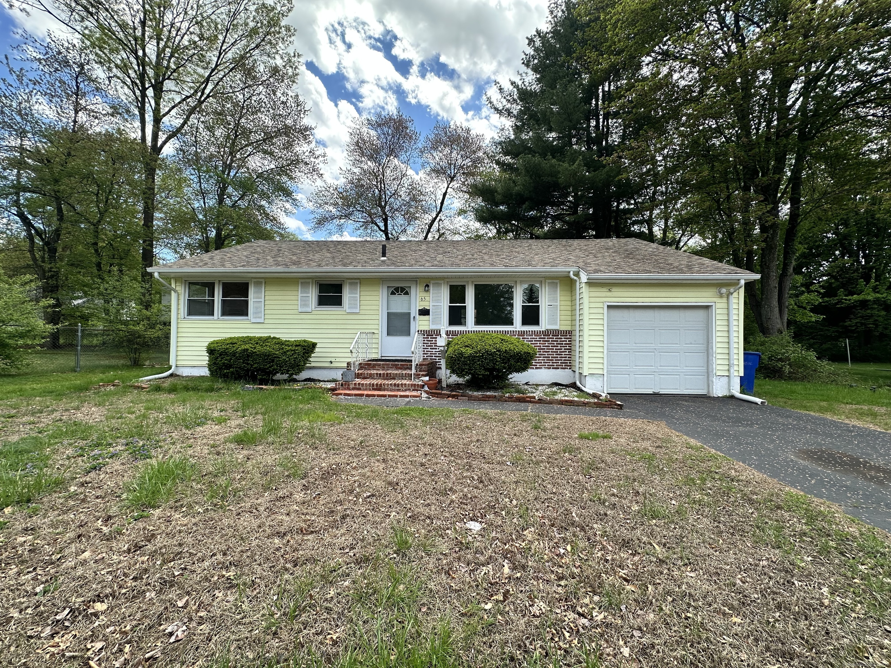 a view of a house with a yard and large tree