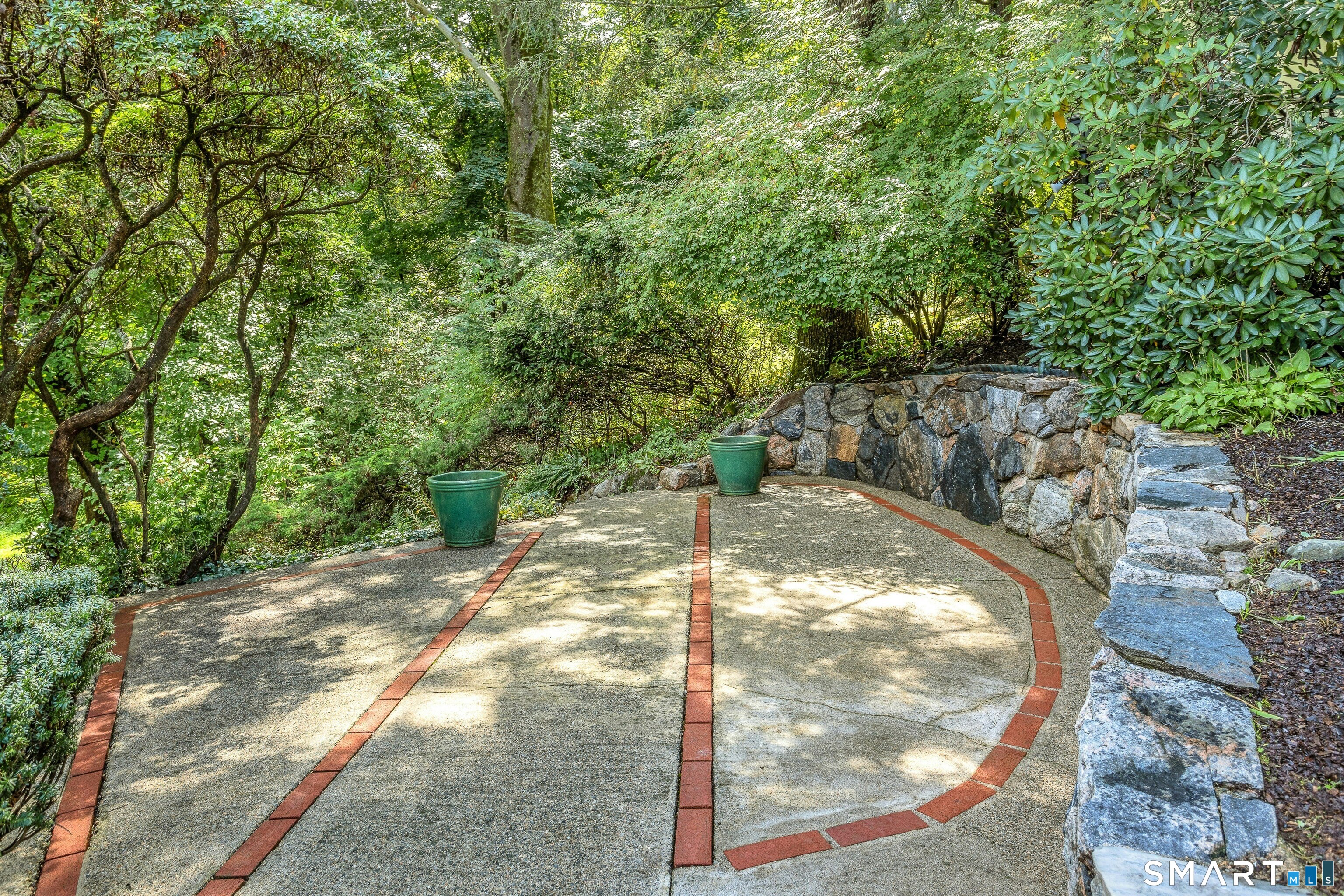 Just One of the Many Private Outdoor Spaces, Featuring Craftsman Stonework, Mature Plantings, and Elegant Exterior Lighting.
