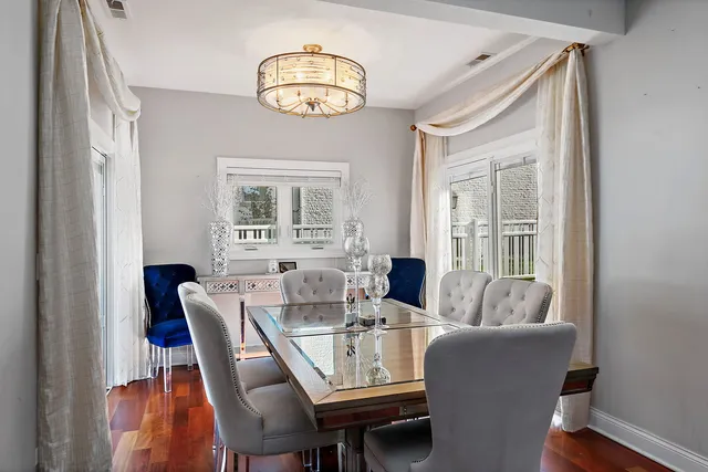 a dining room with furniture a chandelier and wooden floor