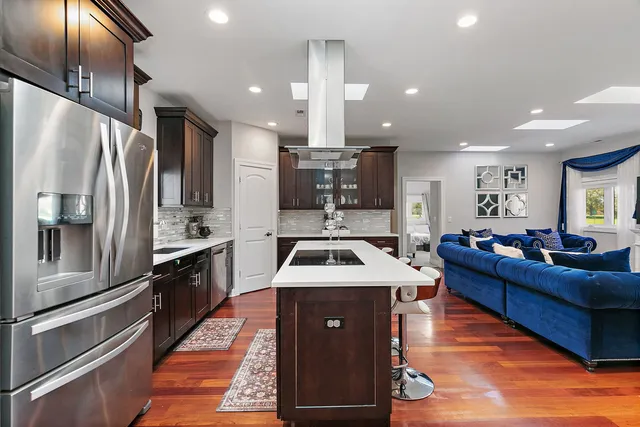 a kitchen with stainless steel appliances kitchen island granite countertop a refrigerator a sink and a stove