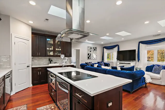 a kitchen with a stove a sink dishwasher and a refrigerator with wooden floor