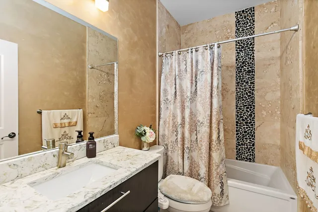 a bathroom with a granite countertop sink toilet and shower