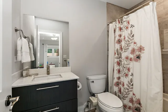 a bathroom with a sink a toilet and shower curtain