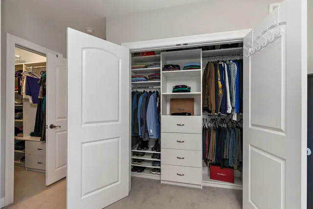 a view of walk in closet with clothes and shoes