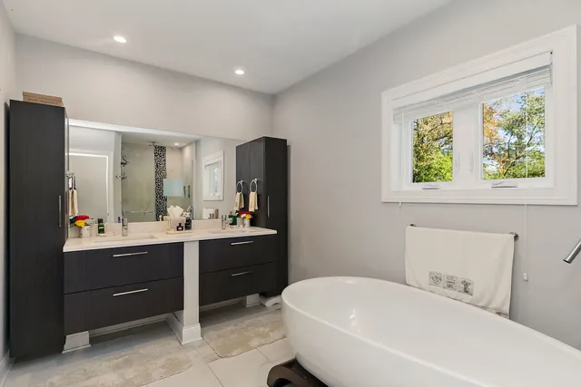 a bathroom with a tub sink and mirror