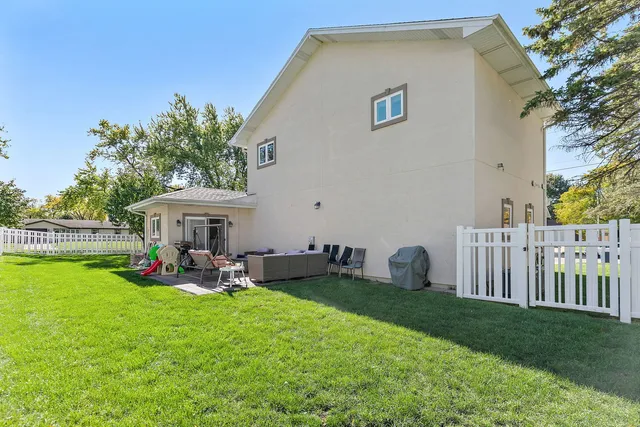 a front view of a house with garden and sitting area