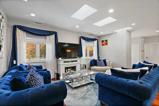 a living room with furniture a flat screen tv and a window