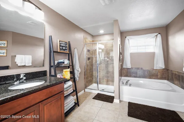 a spacious bathroom with a tub sink shower and mirror