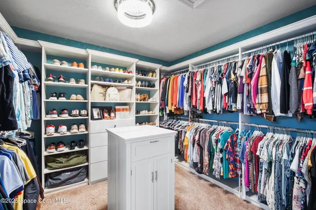 a view of walk in closet with clothes and shoes