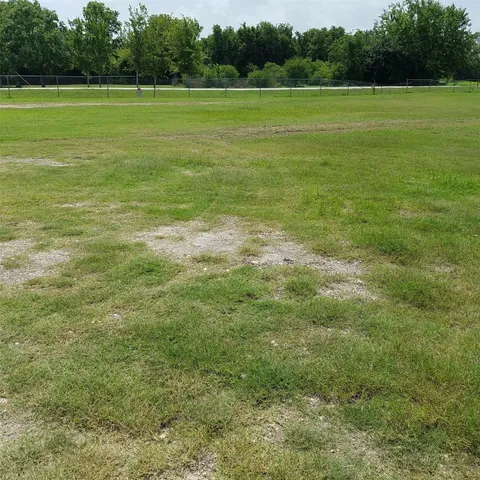a view of a green field with wooden fence