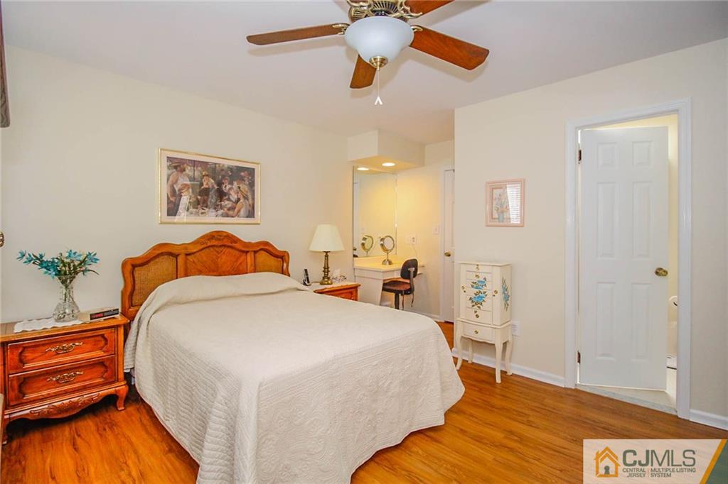 2106 Timber Oaks Road, Unit 2106 Edison, NJ 08820 - Photo 19 of 25 a bedroom with a bed and a chandelier