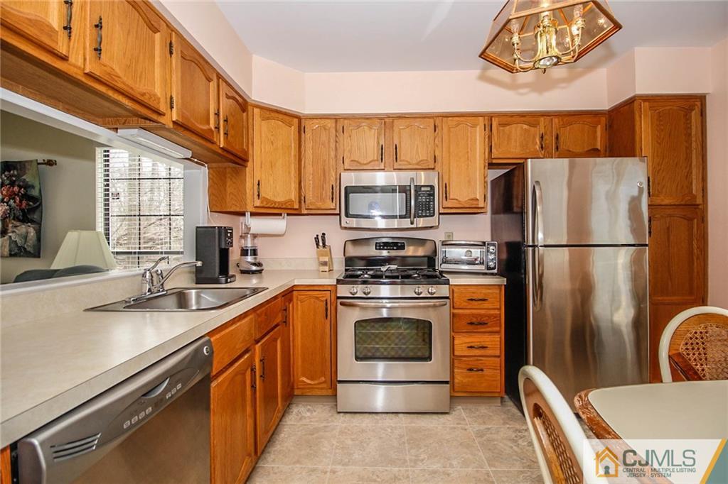 2106 Timber Oaks Road, Unit 2106 Edison, NJ 08820 - Photo 9 of 25 a kitchen with stainless steel appliances granite countertop a refrigerator a stove a sink and a microwave