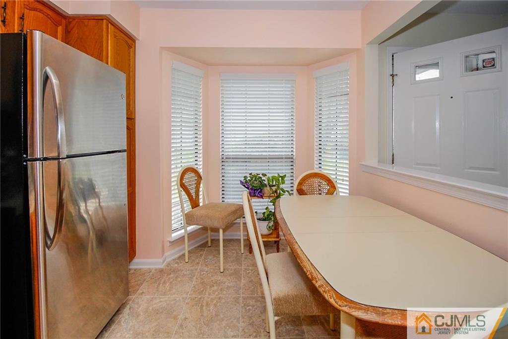 2106 Timber Oaks Road, Unit 2106 Edison, NJ 08820 - Photo 10 of 25 a balcony with chairs and a refrigerator
